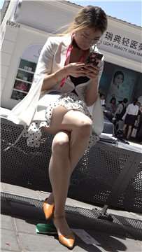 低头玩手机的丝袜高跟气质美女
