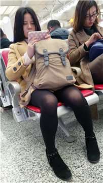 4k-高铁站候车室拍摄低头玩手机的黑丝美腿女孩