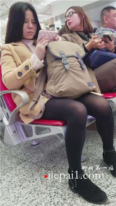 4k-高铁站候车室拍摄低头玩手机的黑丝美腿女孩