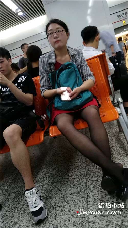 街拍黑丝眼镜妹，玩手机真入迷