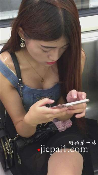 地铁上低头玩手机的女孩，一双高跟很抢眼。
