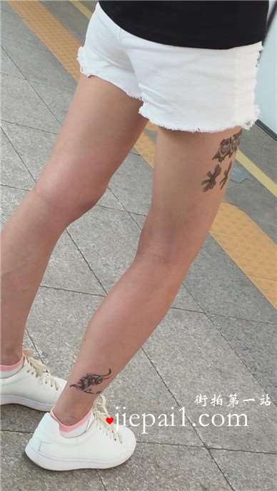 大腿上满是纹身的狂野妹子，白腿热裤板鞋好身材。