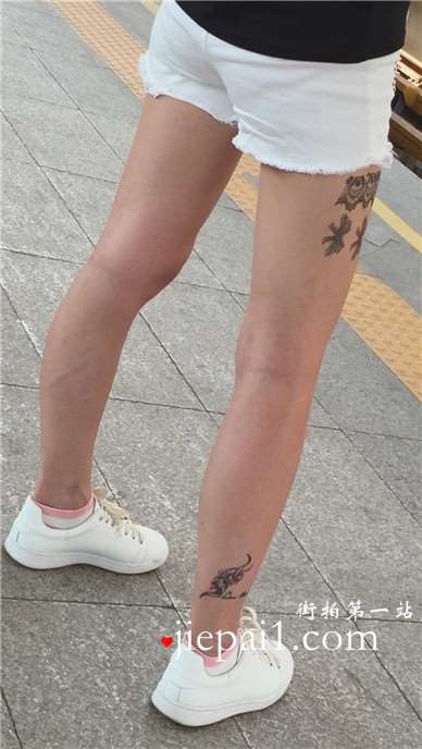 大腿上满是纹身的狂野妹子，白腿热裤板鞋好身材。