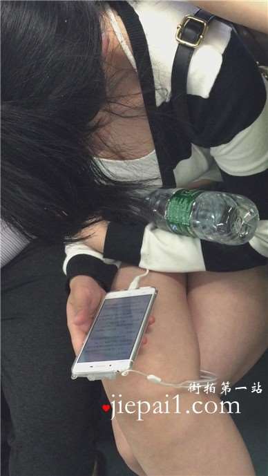地铁上只顾着低头玩手机的女孩