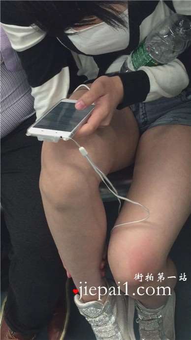 地铁上只顾着低头玩手机的女孩