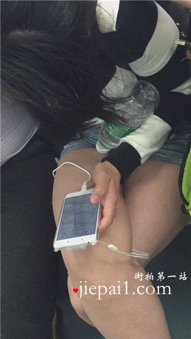 地铁上只顾着低头玩手机的女孩