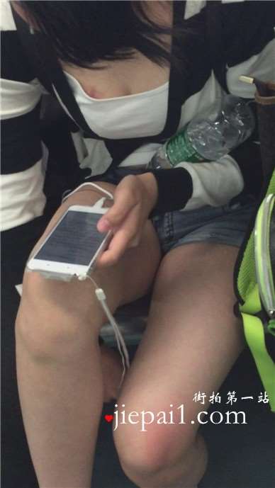 地铁上只顾着低头玩手机的女孩