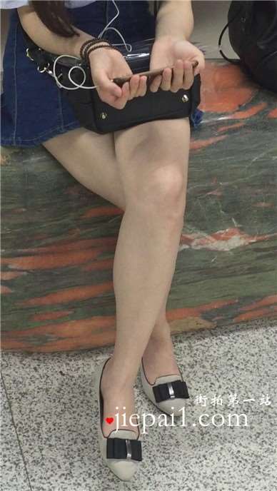 尖嘴高跟齐逼牛仔短裙妹子坐在玉石上看手机视频。