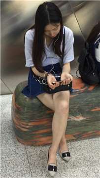 尖嘴高跟齐逼牛仔短裙妹子坐在玉石上看手机视频。