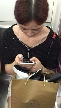 低头玩手机入迷的美女，腿腿真白。