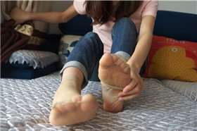 牛仔裤清纯美女床上展示美脚丫