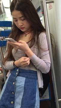 丰满长发牛仔裙美女，就这么一动不动的玩手机，任你摄。