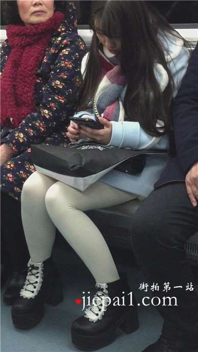 低头玩手机的白丝袜美腿可爱萌妹子。