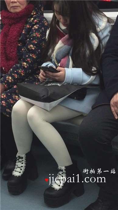 低头玩手机的白丝袜美腿可爱萌妹子。