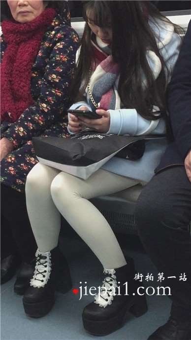 低头玩手机的白丝袜美腿可爱萌妹子。