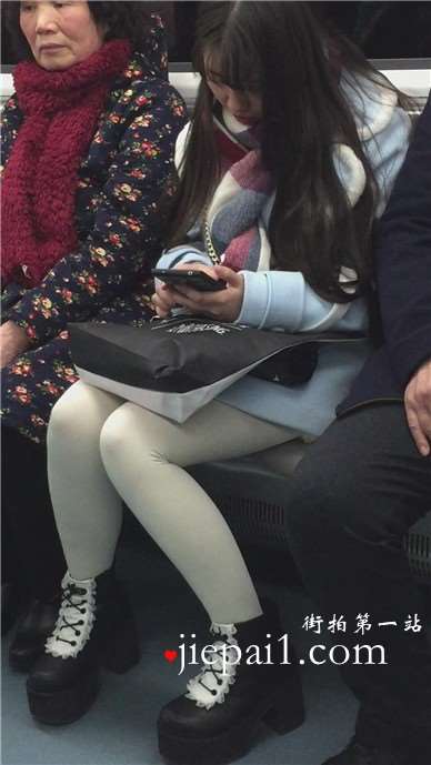 低头玩手机的白丝袜美腿可爱萌妹子。