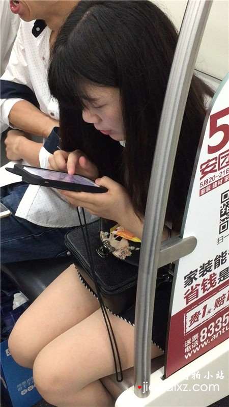 地铁上专心玩手机的美腿小清纯美女