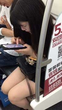 地铁上专心玩手机的美腿小清纯美女