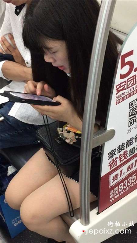 地铁上专心玩手机的美腿小清纯美女