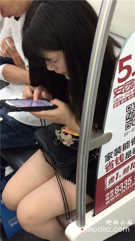 地铁上专心玩手机的美腿小清纯美女