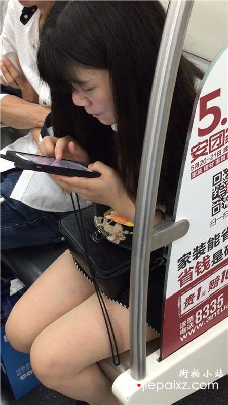 地铁上专心玩手机的美腿小清纯美女