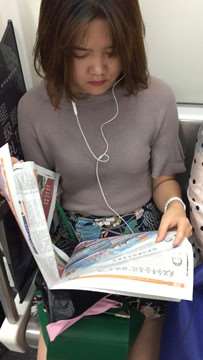 地铁上拍摄看报纸的美女，清纯甜美。