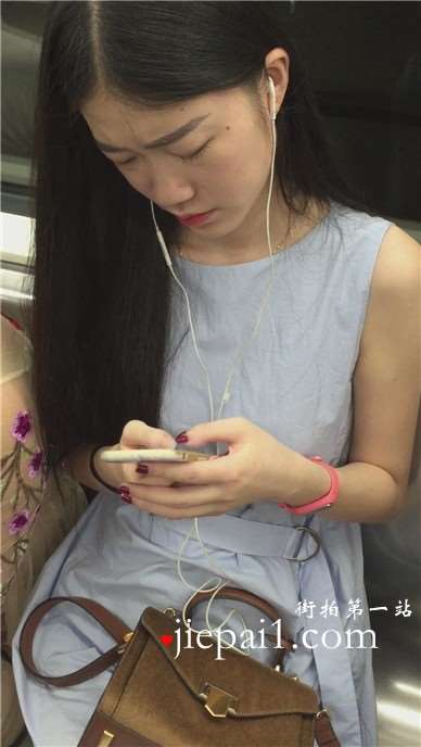 地铁拍摄低头玩手机的小清新美女