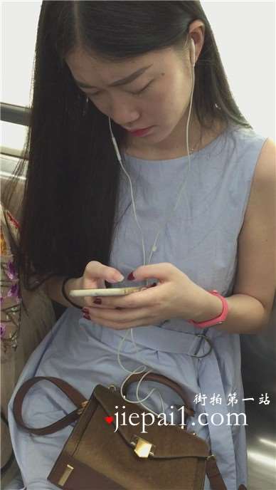地铁拍摄低头玩手机的小清新美女