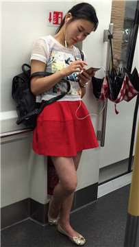 街拍地铁上听歌的红裙清纯颜值美女
