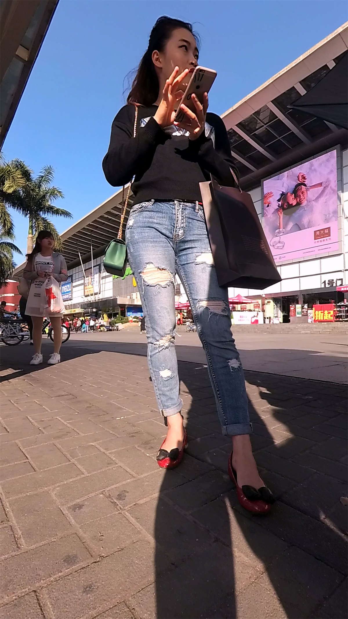 紧身破洞牛仔裤黑色毛衣美女等公交车