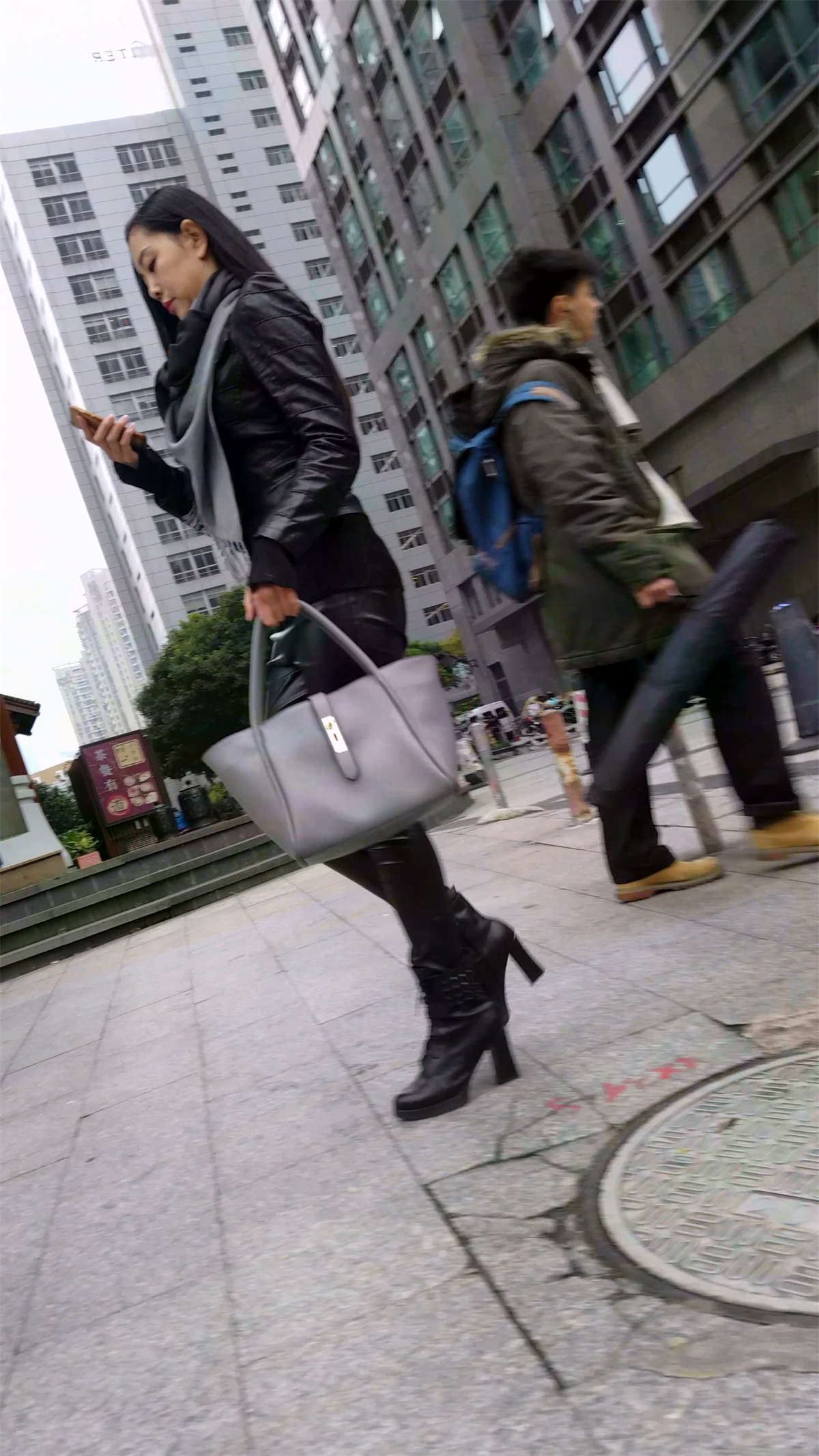 走路急匆匆的黑色皮裤长腿长发少妇