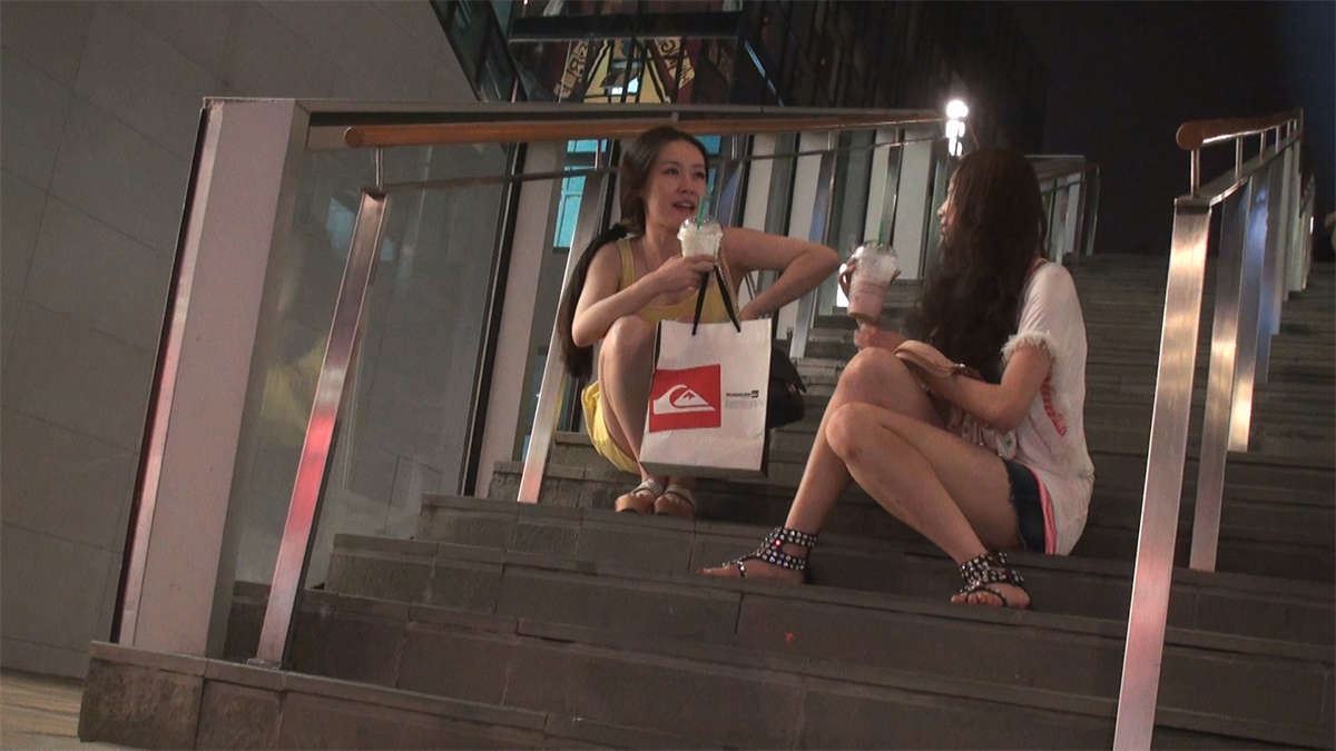 坐在楼梯上聊天的两位美女