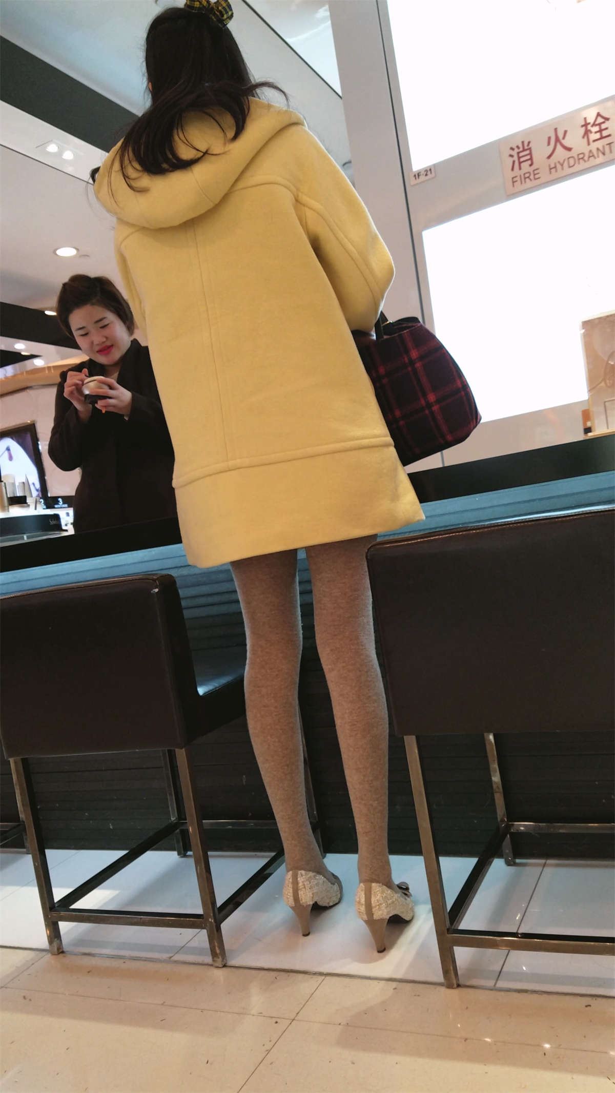 商场买化妆品的黄色风衣丝袜高跟少妇