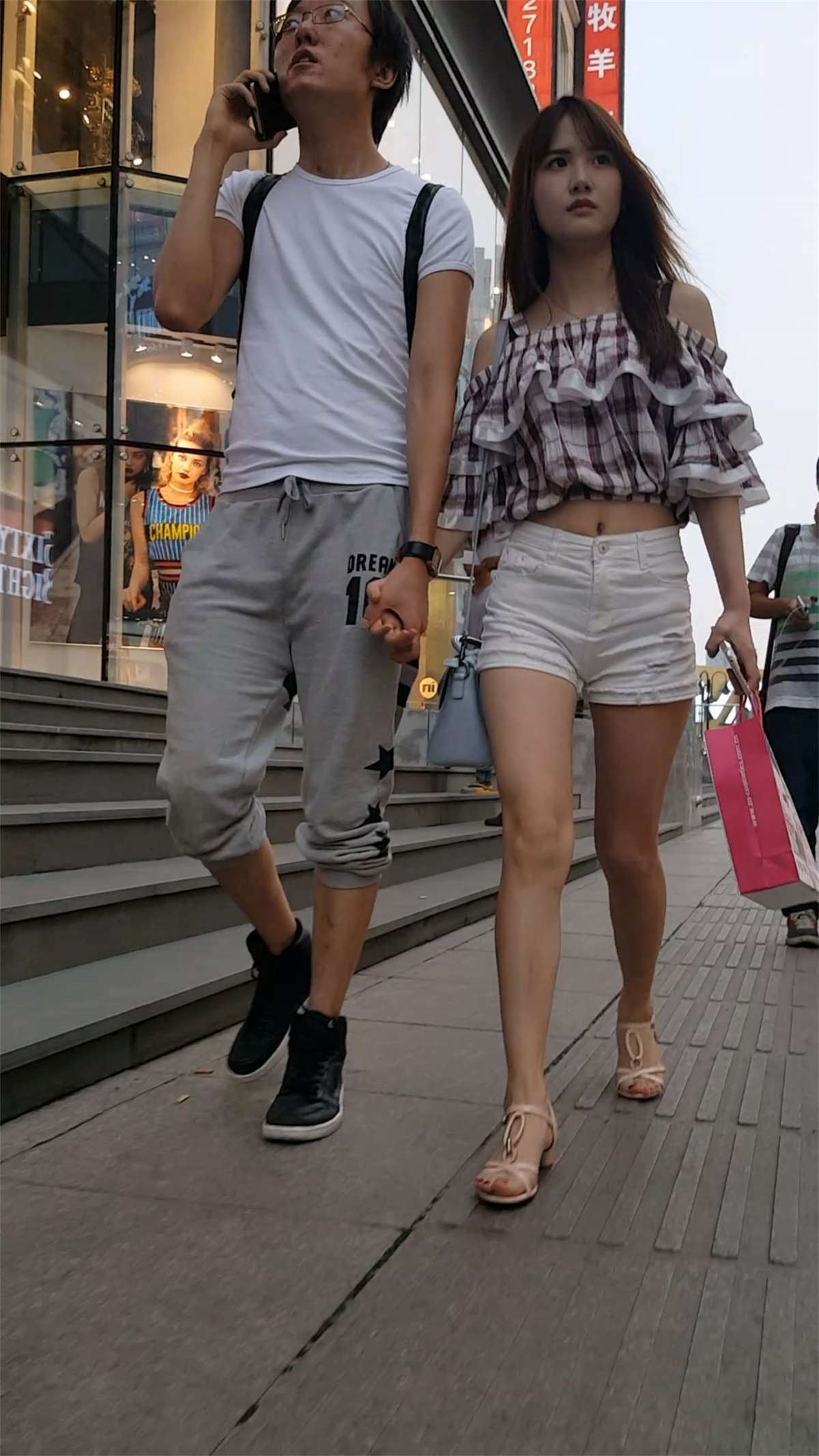 白色紧绷热裤长发美女和男友一起逛街
