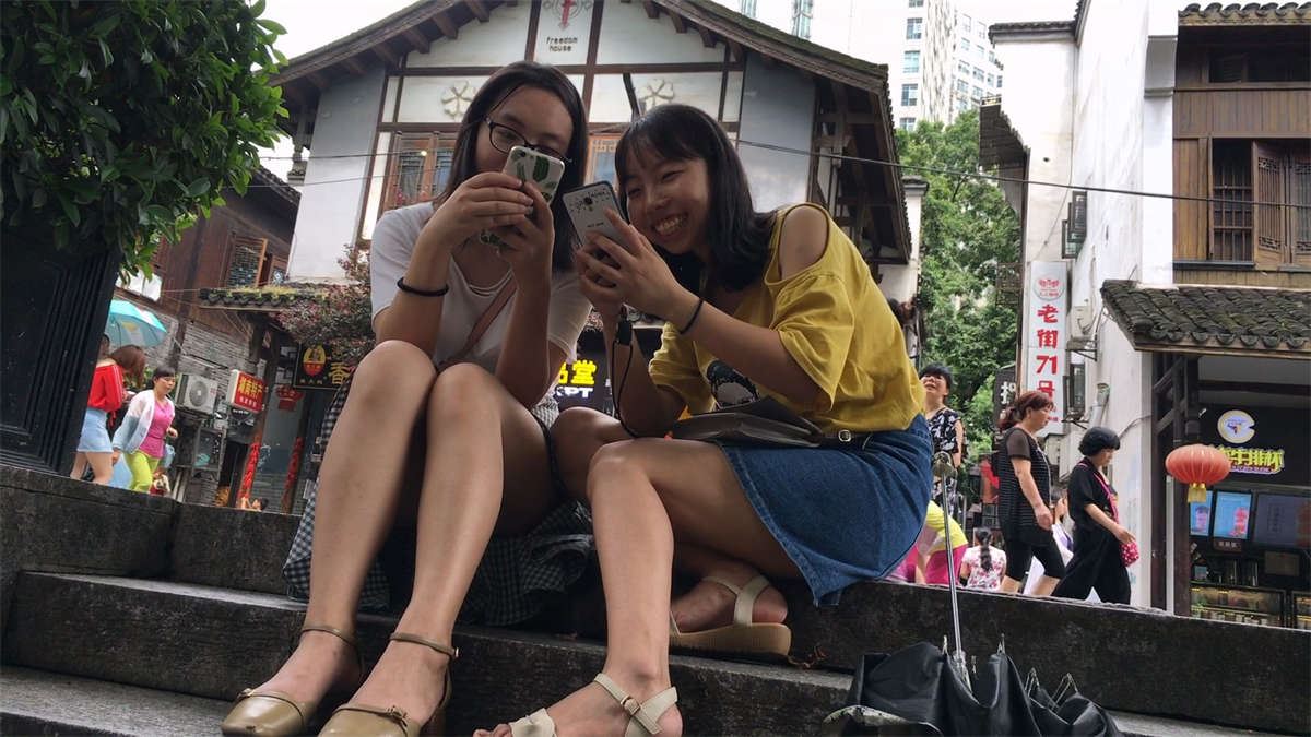 坐在台阶休息的两个美女