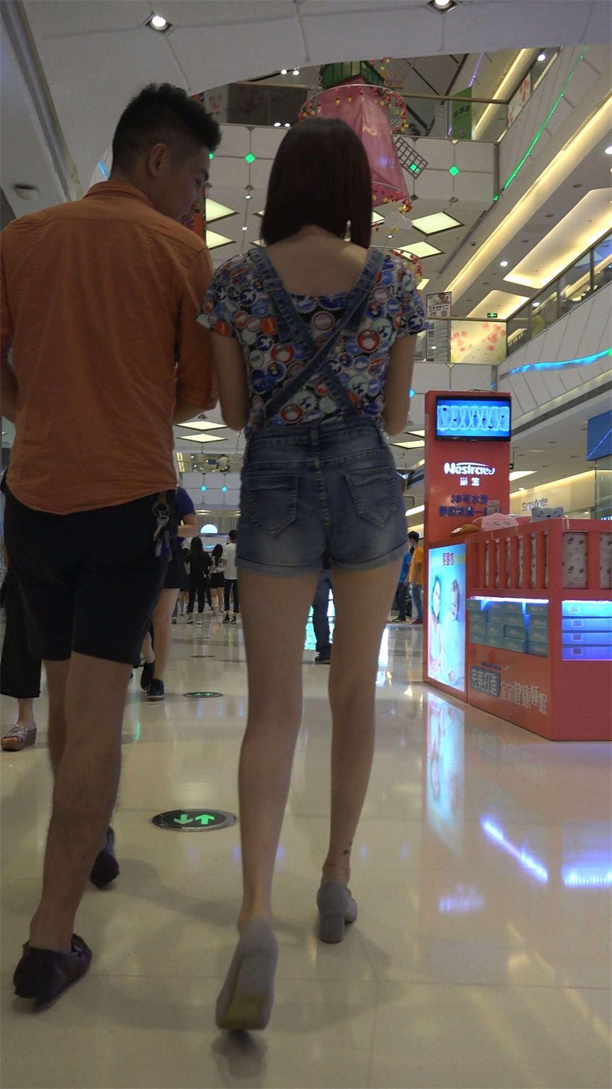 和男友一起逛商场的背带裤美女