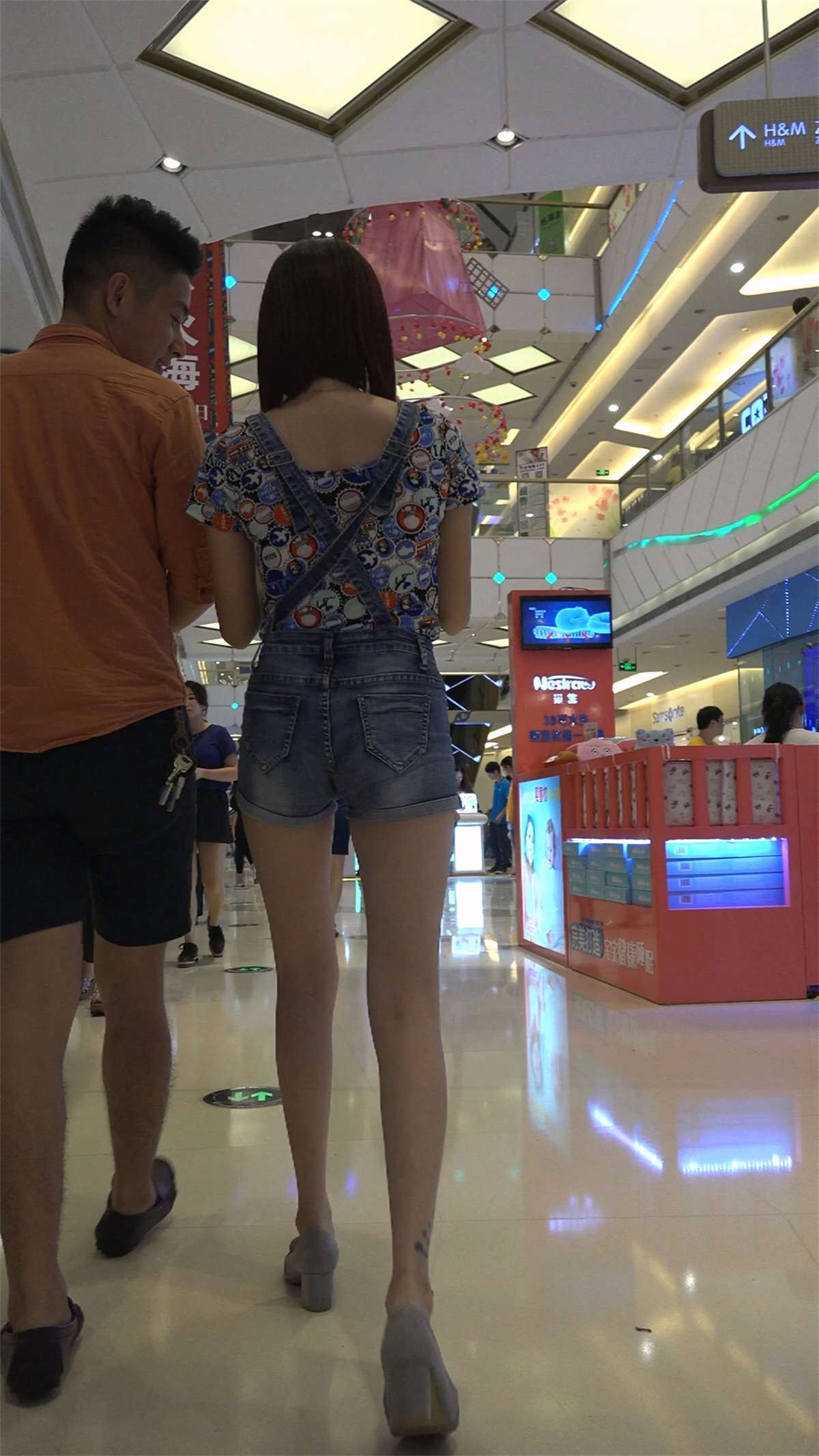 和男友一起逛商场的背带裤美女