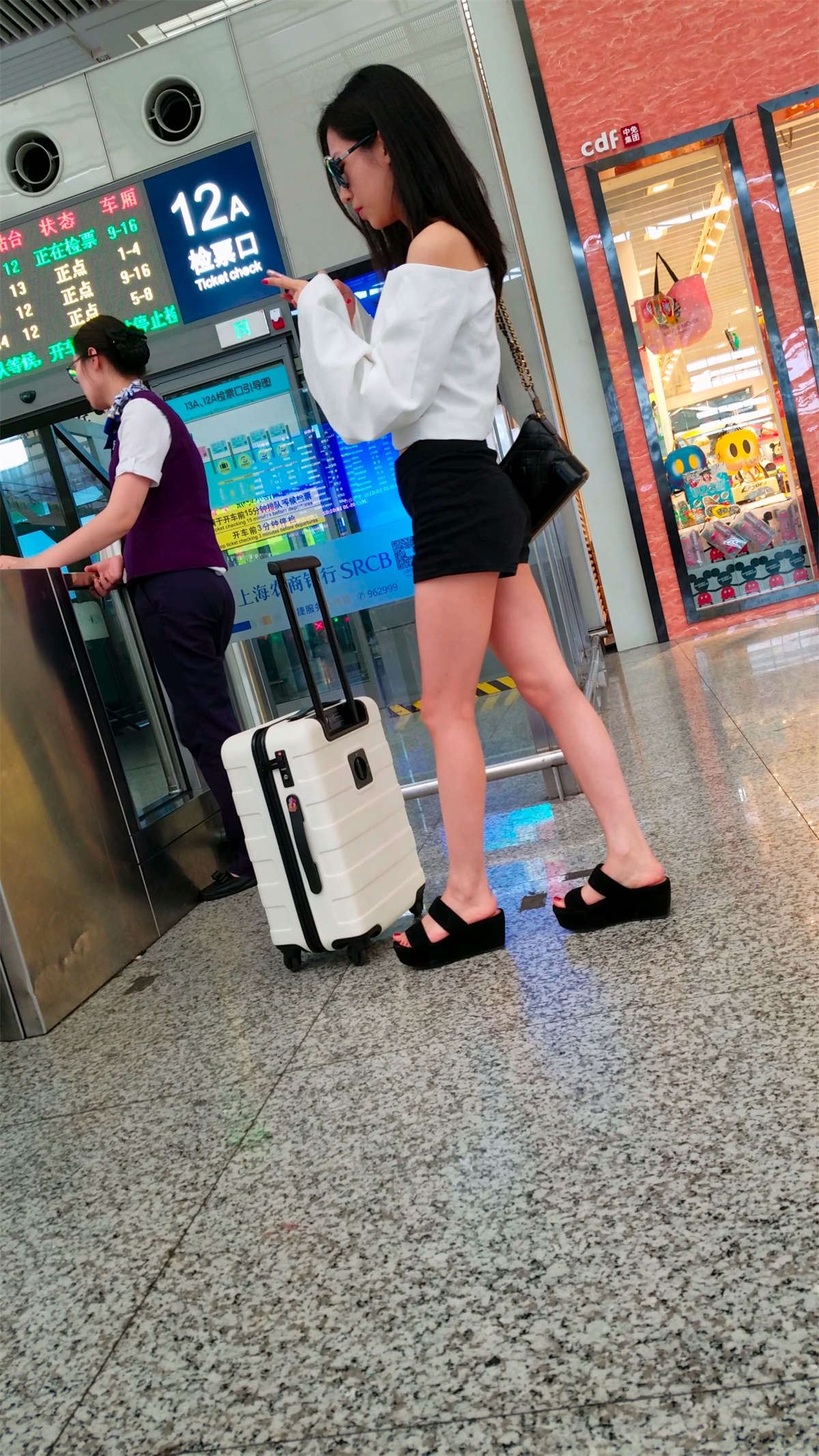 火车站跟拍黑色牛仔热裤极品白腿长发墨镜美女