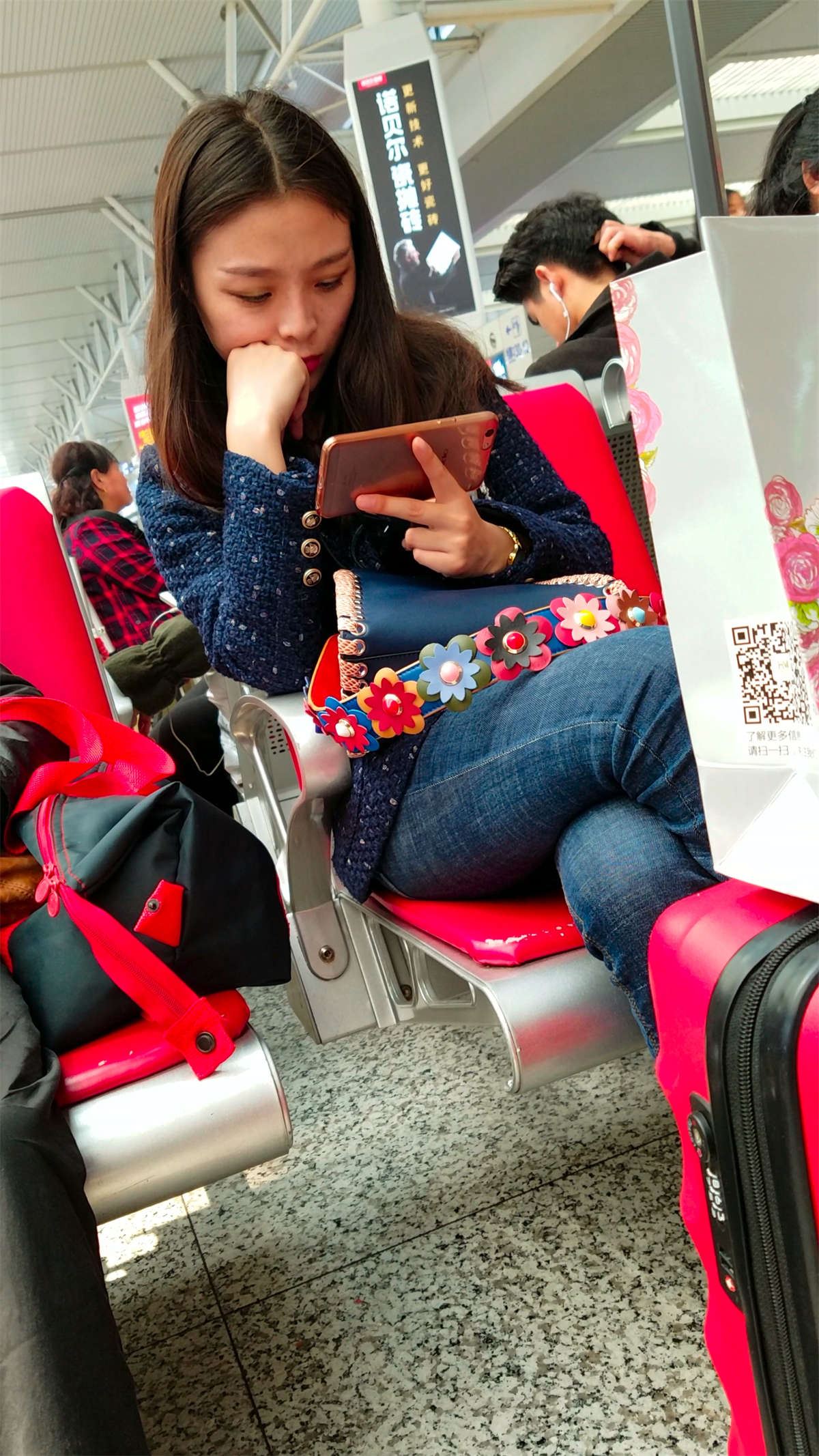 高铁站候车的蓝色紧身牛仔裤长发美少妇