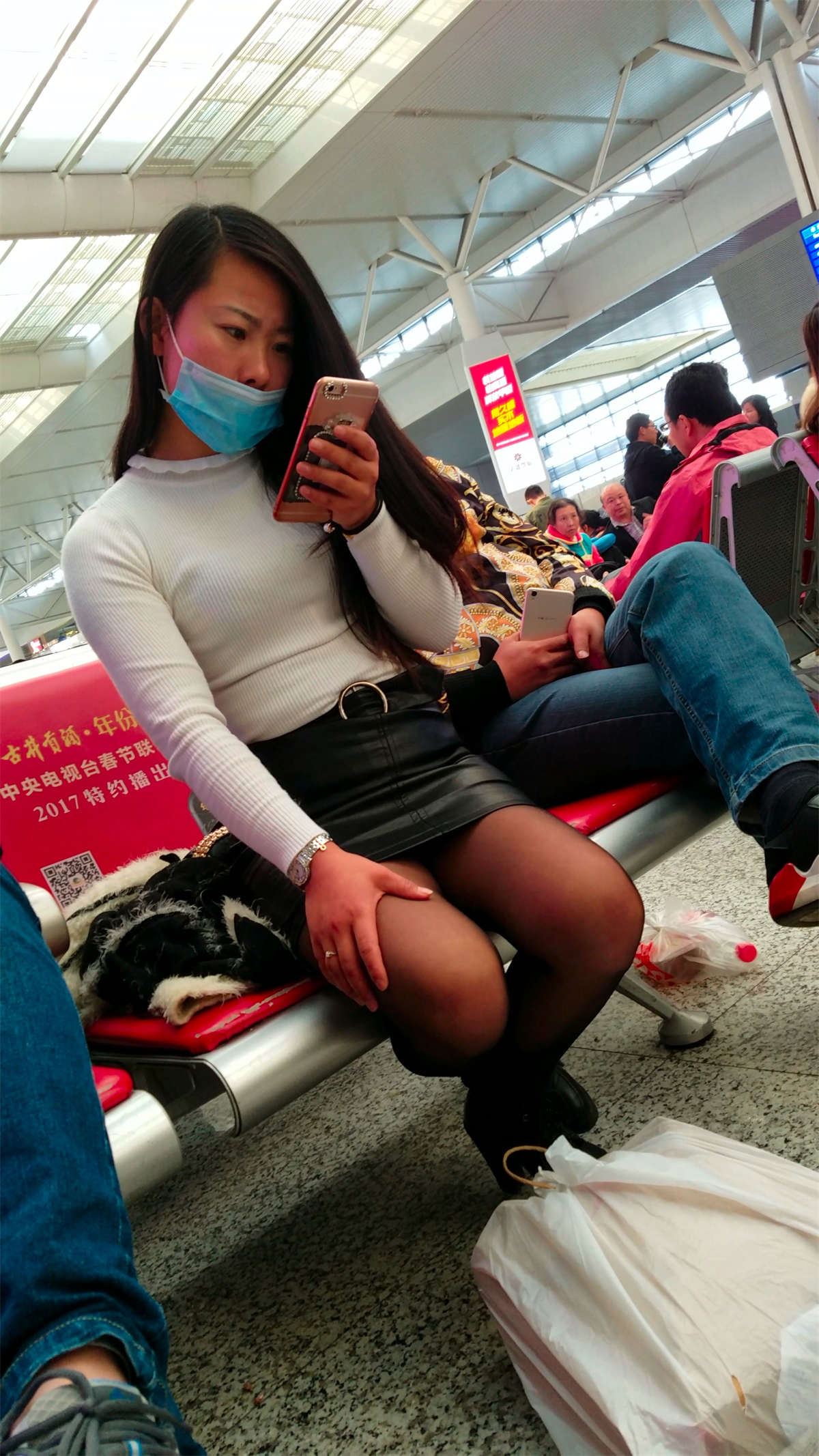高铁站候车的黑色紧绷包臀皮裙黑丝长发少妇