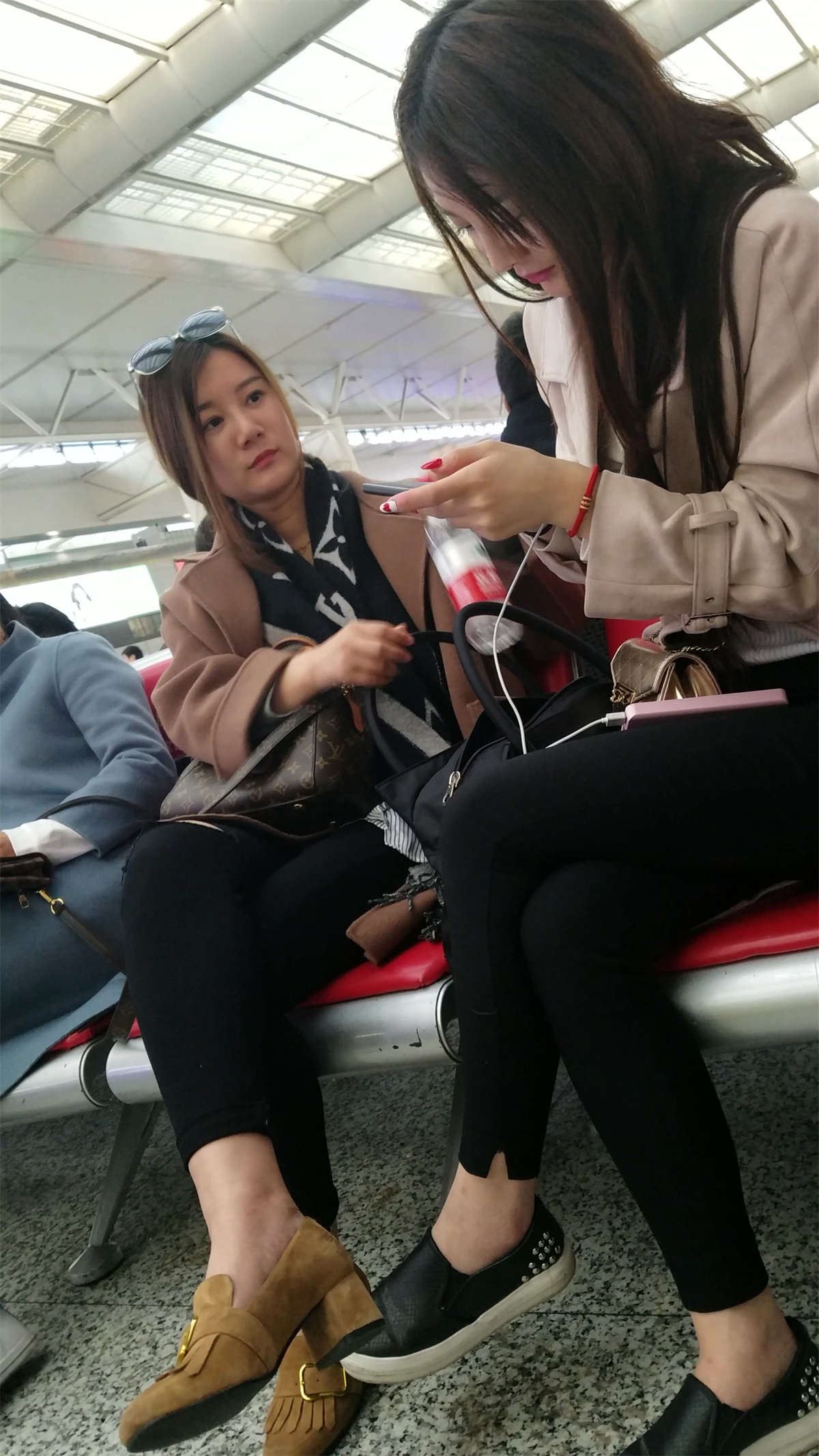 高铁站候车的两个黑色紧裤漂亮美女
