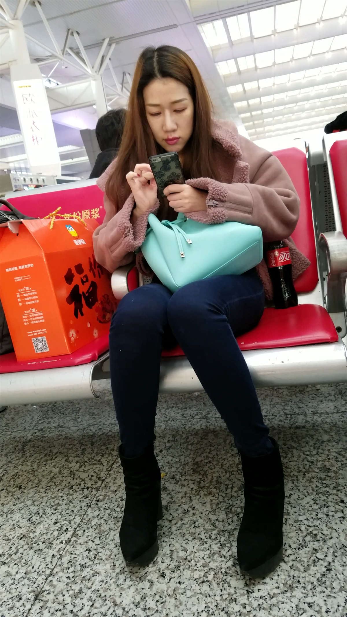 高铁站拍摄蓝色紧身牛仔裤漂亮长发美女