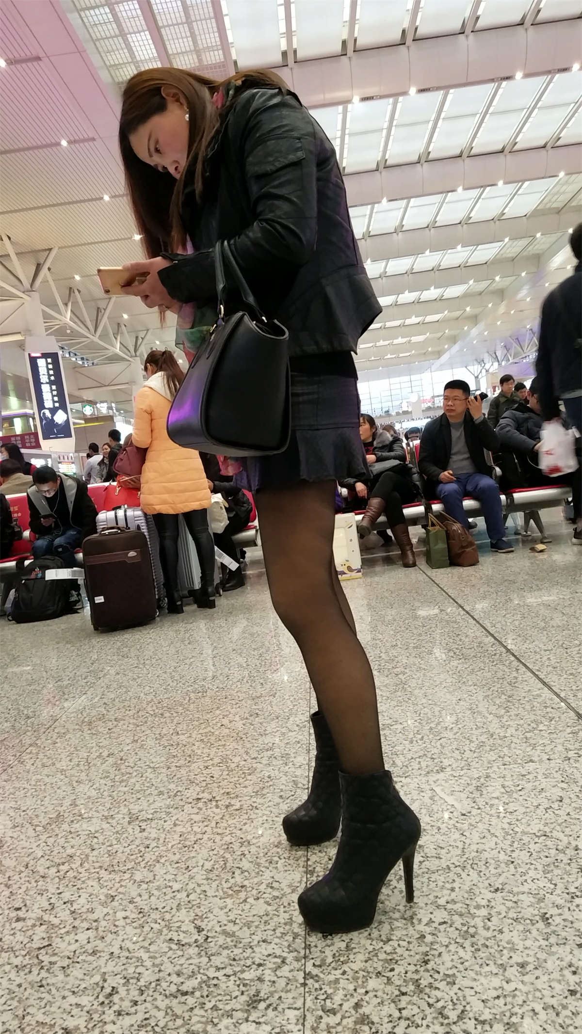 高铁站拍摄超短裙黑色丝袜高跟长发少妇