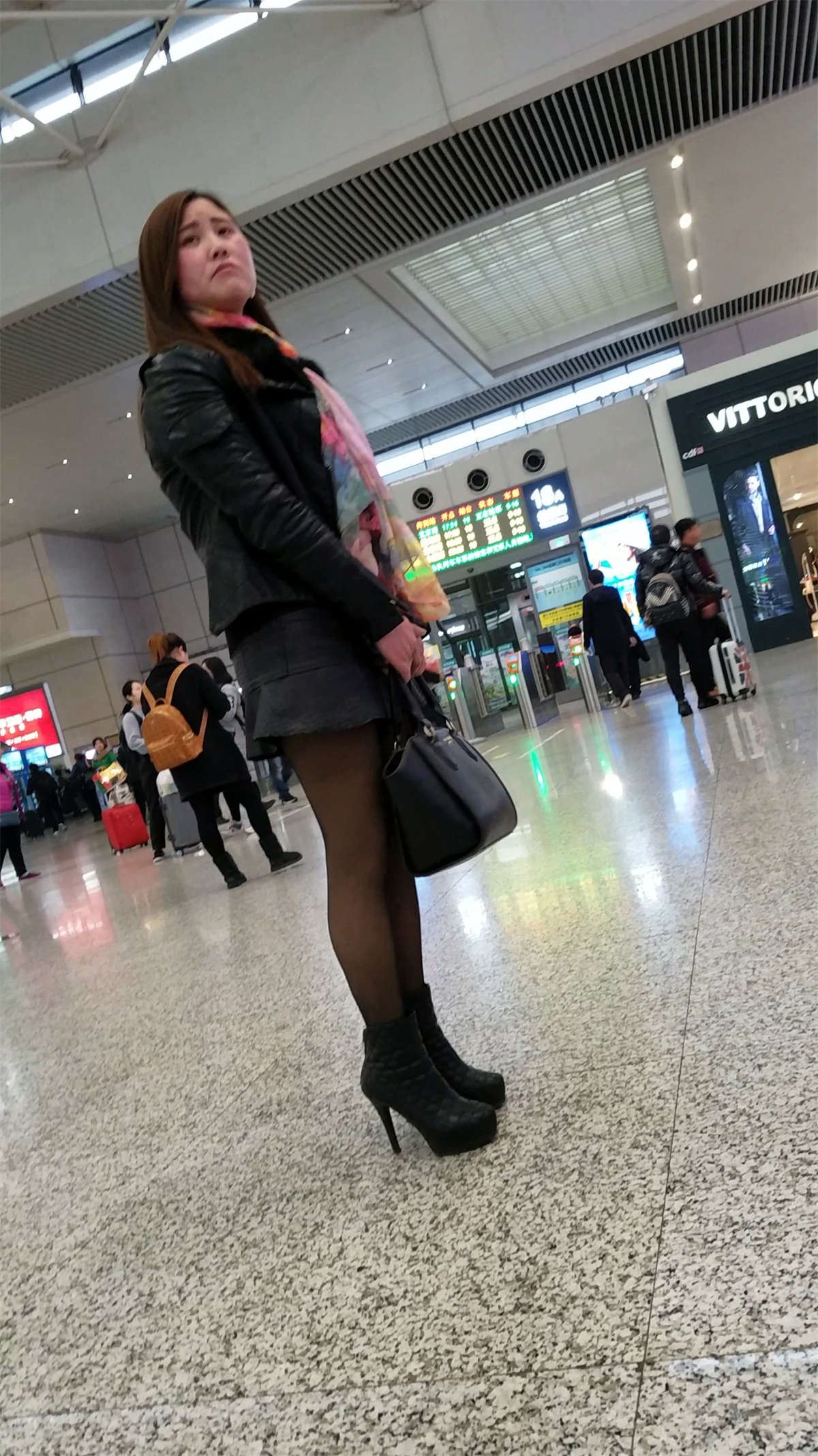 高铁站拍摄超短裙黑色丝袜高跟长发少妇