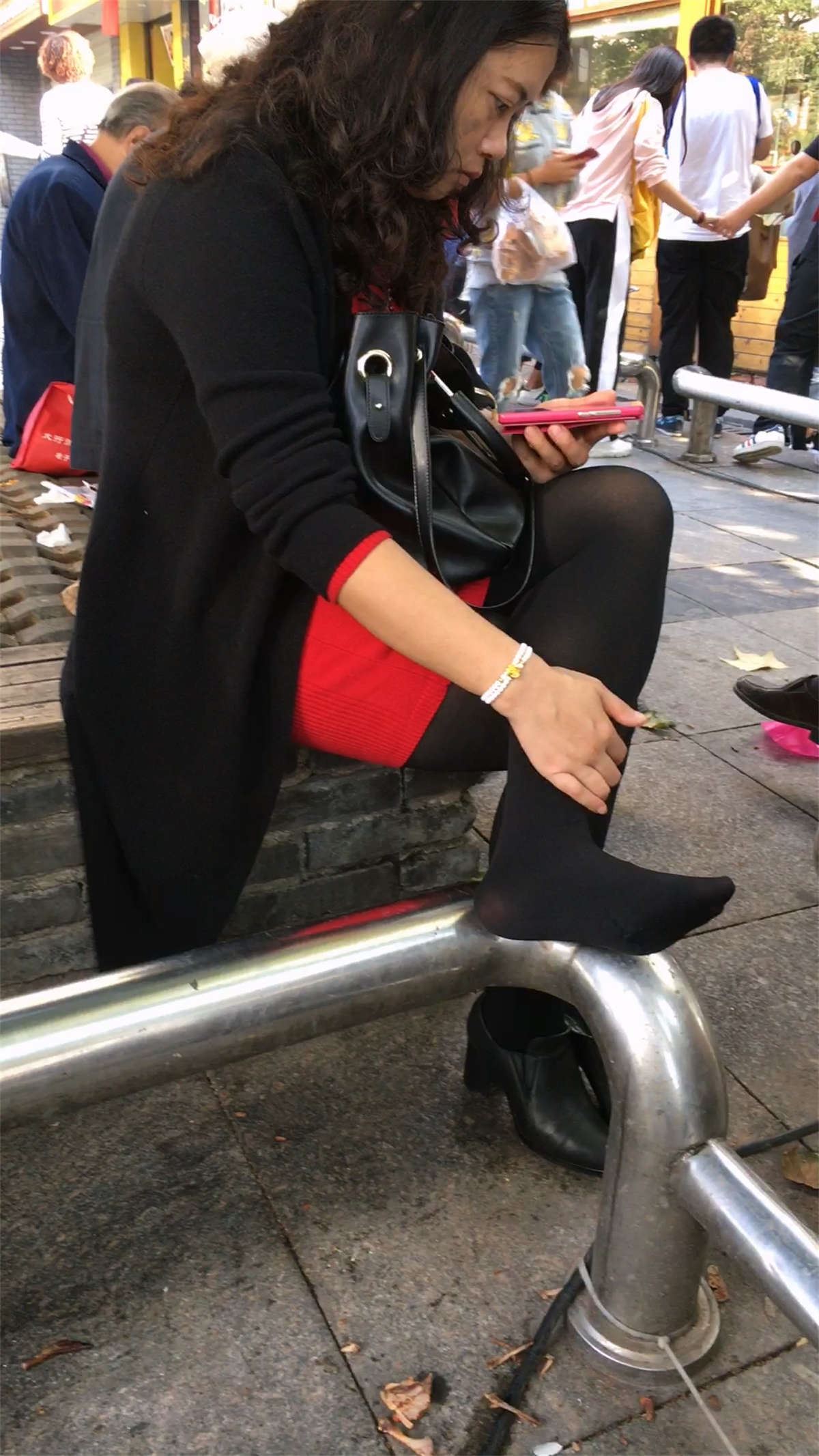 花坛休息的黑色丝袜黑色高跟红色包臀裙白肤少妇