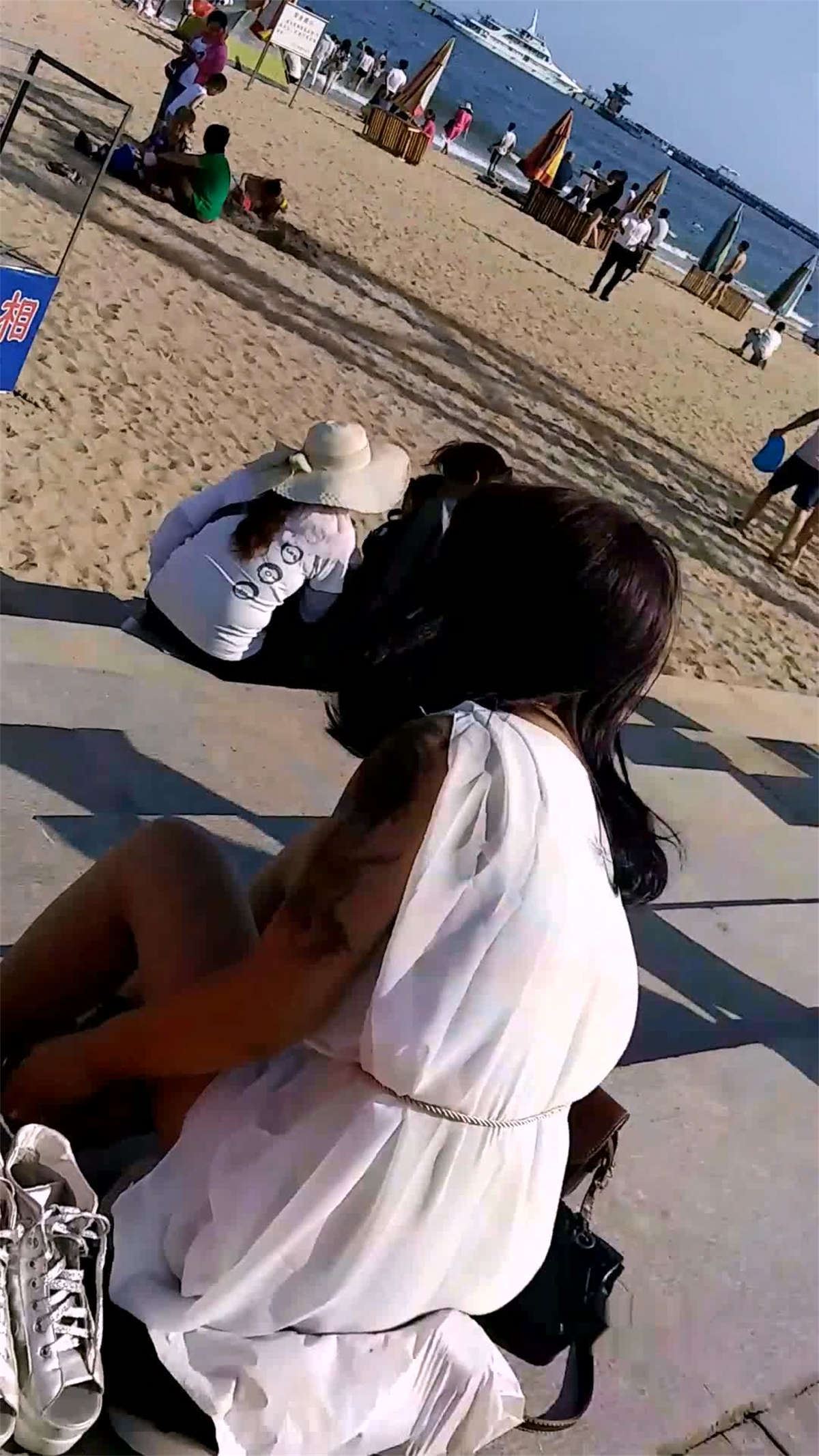 海滨沙滩上的小美女在换丝袜