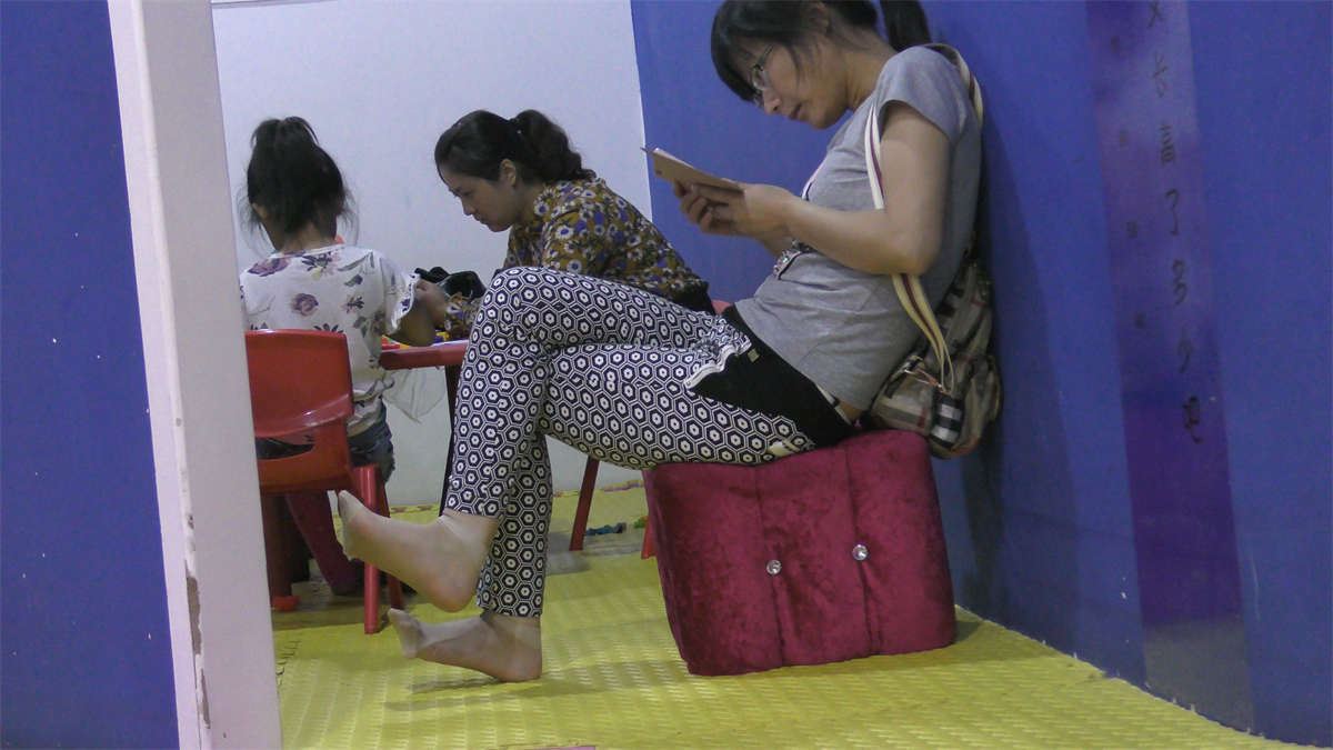 游乐园玩手机的孩子妈