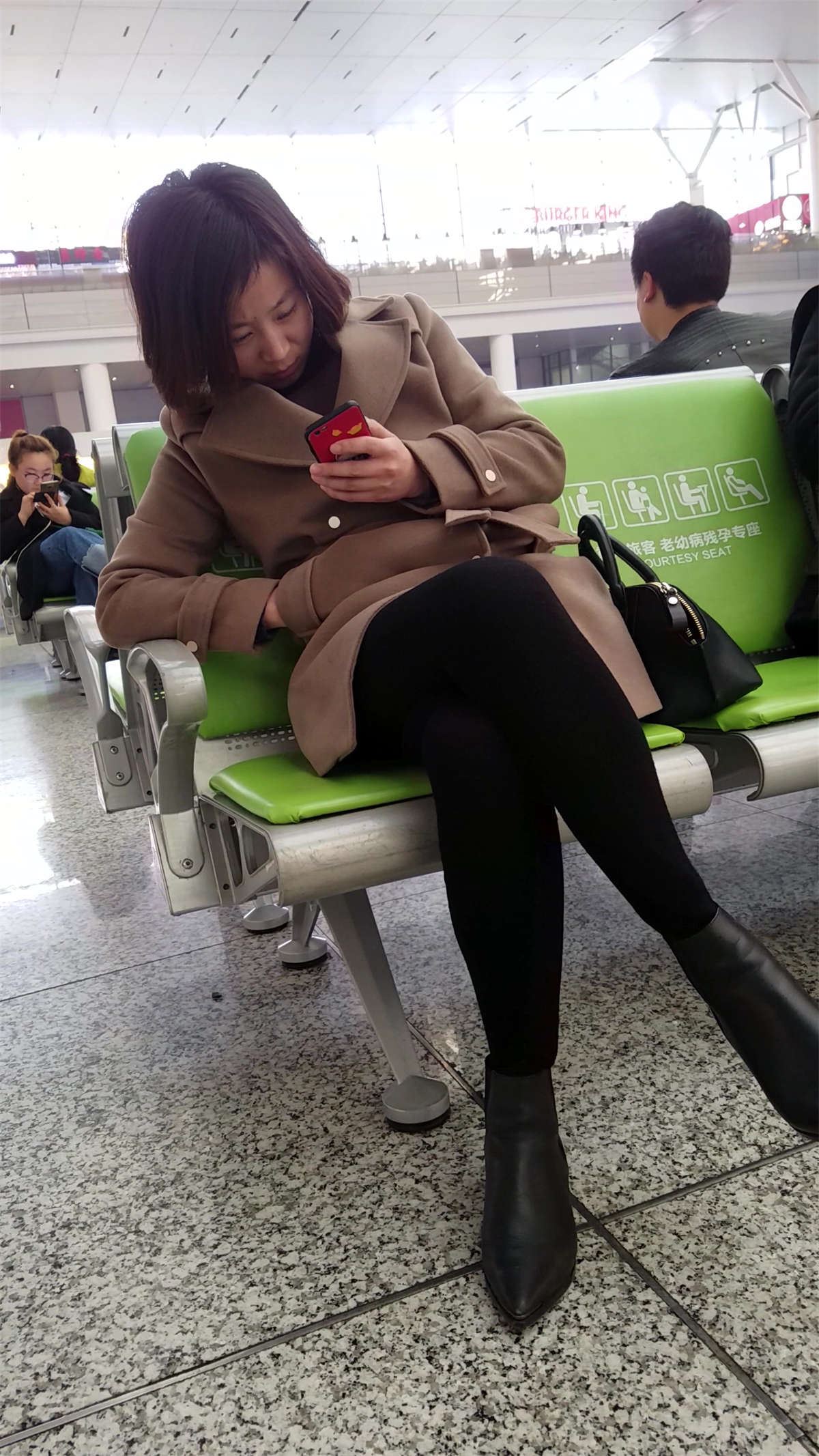 候车室的黑色打底裤美眉低头玩手机