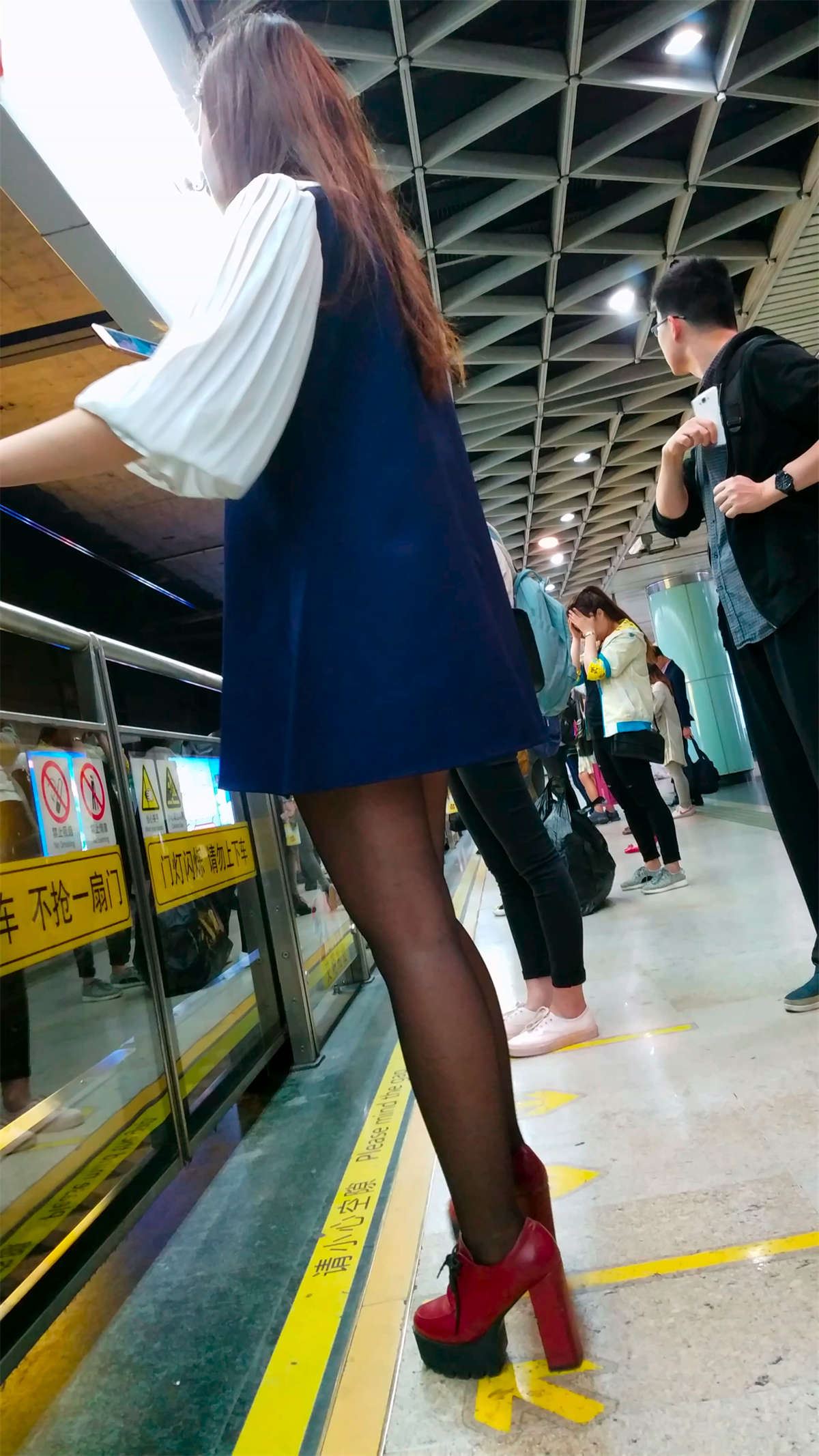 地铁站候车的超高跟黑色丝袜短裤长发美女