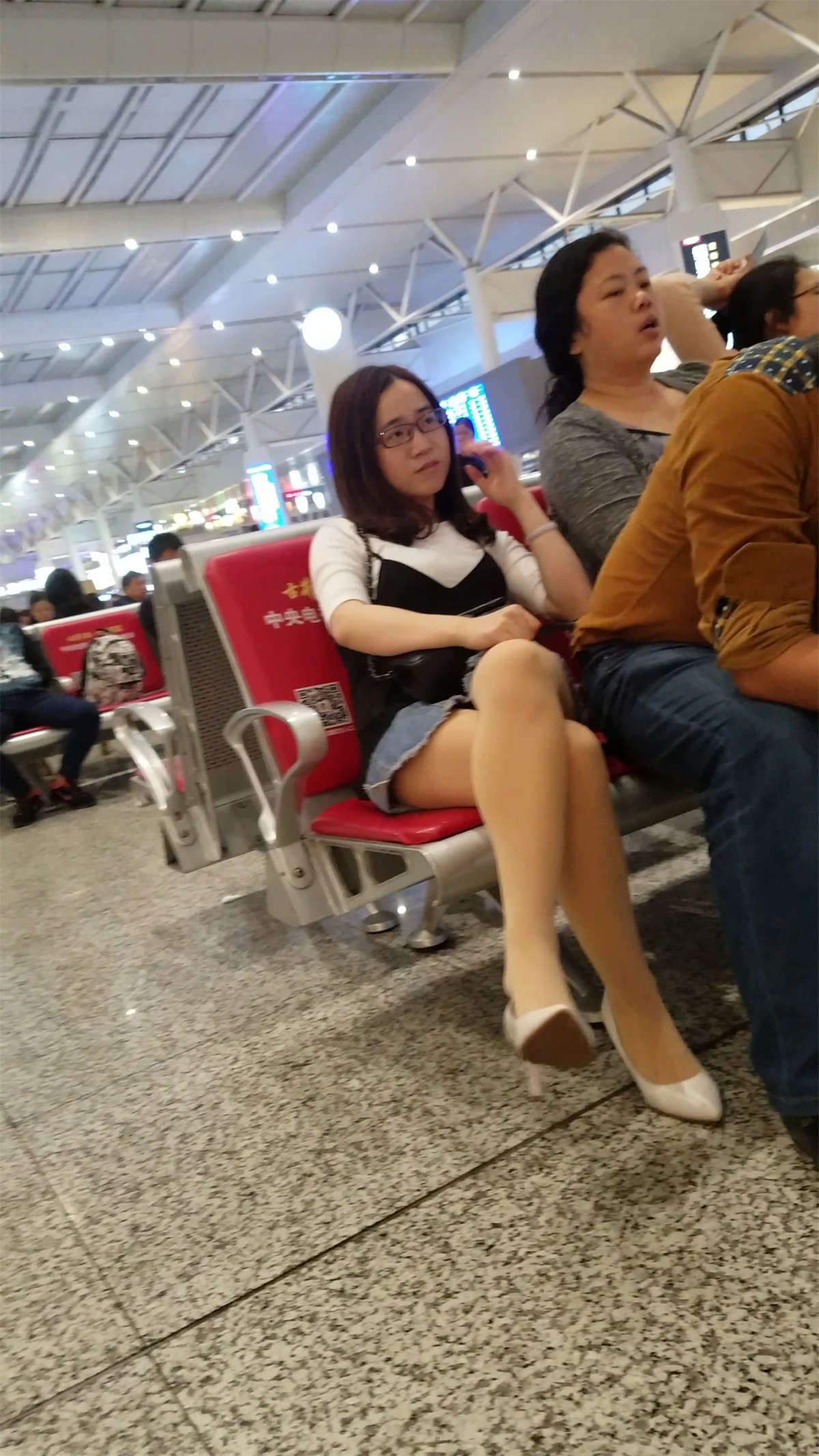 高铁站等车的白色高跟肉色丝袜牛仔短裙少妇